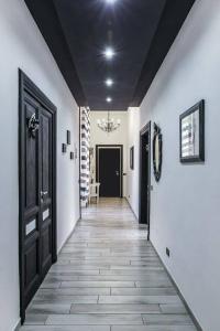 un corridoio con pareti bianche, porte nere e pavimenti piastrellati di Lazy Gio Guest House a Roma