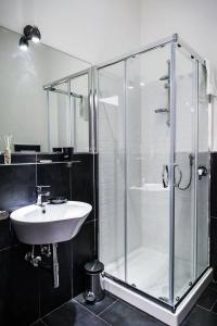 un bagno con doccia in vetro e lavandino di Lazy Gio Guest House a Roma