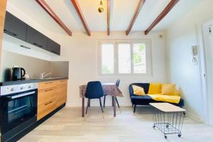 uma cozinha e sala de estar com uma mesa e um sofá em Appartement cosy avec jardin chaleureux em Laon