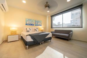 卡塔赫納的住宿－Casa Bahía Apartamento，一间卧室配有一张床、一张沙发和一个窗口