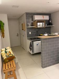 uma cozinha com um balcão e um fogão forno superior em Laguna Beach Flat em Porto de Galinhas