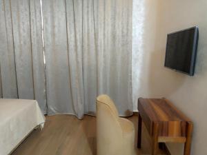 a room with a bed and a table and a television at Palm’s Motel in Agadir