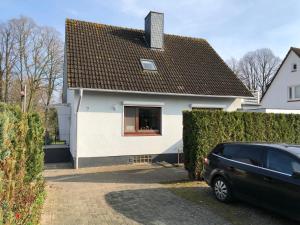 a car parked in front of a white house at An der Allee 7 App in Dahme