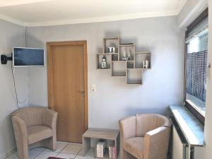 a room with two chairs and a table and a television at An der Allee 7 App in Dahme