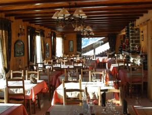 a restaurant with tables and chairs in a room at Arc en Ciel in Châtel