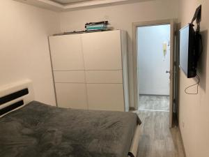 a bedroom with a bed and a dresser and a television at Stan na dan Bogdan in Podgorica