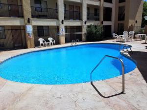 a large blue swimming pool in front of a hotel at Red Roof Inn Albuquerque - Midtown in Albuquerque