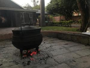 a pot on a fire in a yard at Danamara Garden Studios in Phalaborwa