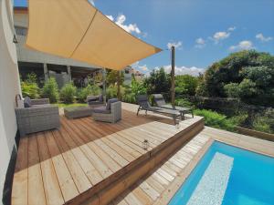 a wooden deck with an umbrella and a pool at Kozycoco - Suite Kozy - séjour tropical au calme in Schœlcher