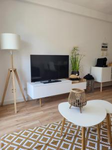 a living room with a large tv and a white table at somtresapartament in Platja d'Aro