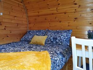 1 dormitorio con 1 cama en una pared de madera en Gorse Hill Glamping en Newcastle