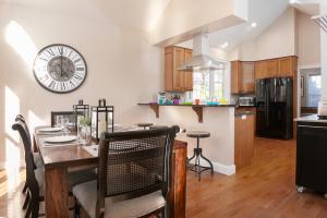 a kitchen with a table and a clock on the wall at Mountain Shadows BRAND NEW Luxurious House with Heated Pool - Games - And More Near Asheville! in Leicester