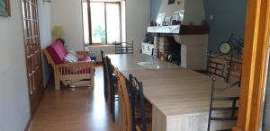 a kitchen with a table and chairs and a living room at Maison pour nombreuses personnes in Pousseaux