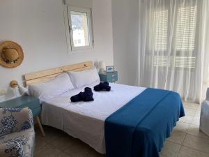 a bedroom with a bed with a blue blanket on it at CASA MARITE in San José