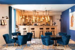 a bar with blue chairs and tables in a room at SOWELL HOTELS Les Chevaliers in Carcassonne
