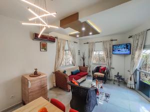 a living room with a couch and a tv at MOOKSQUARE NS SPOT in Douala