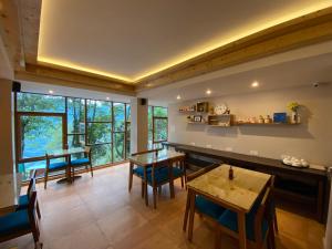 a living room with tables and chairs and a large window at Manaslu in Gangtok