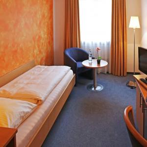 um quarto de hotel com uma cama e uma mesa em Hotel Graf Lehndorff zur Messe em Munique