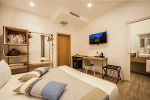 a bedroom with a bed and a desk and a bathroom at NOHA Lifestyle Hotel - Adults Only in Pula