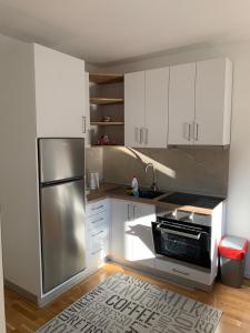 una cucina con armadi bianchi e frigorifero in acciaio inossidabile di VIP Apartment Visoko a Visoko