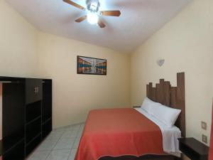 1 dormitorio con 1 cama y ventilador de techo en D' Camino A Casa, en Tequisquiapan