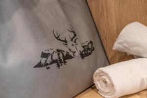 a reindeer on a towel next to a pile of towels at Hotel Gundolf in Sankt Leonhard im Pitztal
