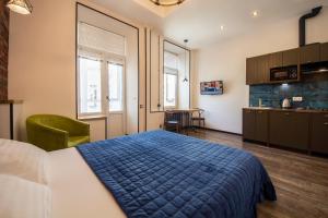 a bedroom with a blue bed and a kitchen at DayFlat Apartments on Mykhailivs'ka in Kyiv