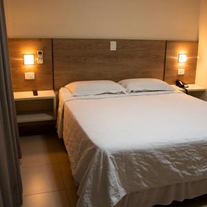 a bedroom with a large white bed with two pillows at Golden Plaza Hotel in Porto Velho