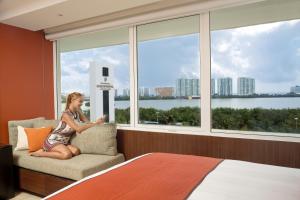 坎昆的住宿－InterContinental Presidente Cancun Resort，坐在窗户房间里椅子上的女人