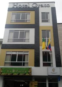 un edificio con banderas colgando fuera de él en Hotel Grato Manizales en Manizales