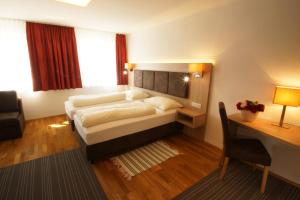 シュトラスヴァルヘンにあるGasthof zur Postのベッドとデスクが備わるホテルルームです。