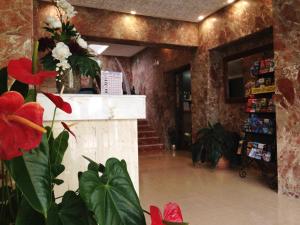 um lobby com flores e um balcão numa loja em Hotel Carmen Teresa em Torremolinos