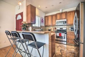 a kitchen with wooden cabinets and bar stools at Sunny SoCal Escape about 5 Mi to Universal Studios! in Burbank