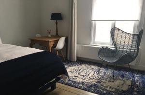 a bedroom with a bed and two chairs and a table at NineT7 in Tilburg