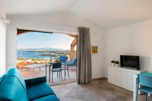 een woonkamer met een blauwe bank en een tv bij Sherden suites - Your House in Sardinia in Golfo Aranci