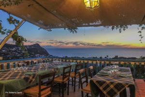 イスキアにあるAppartamenti Bellavistaの海の景色を望むテーブルと椅子付きのレストラン