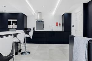 a kitchen with black and white cabinets and a table at Wellington Suites by Sasco Apartments in Blackpool