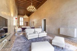 a living room with white furniture and a chandelier at Portego del Drapier in Venice
