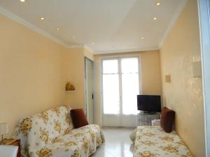 a living room with a couch and a television at Studio Croisette in Cannes