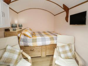 a small bedroom with a bed and two chairs at Glyder Fach in Bangor