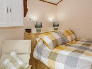 two beds in a small room with two lamps at Glyder Fach in Bangor