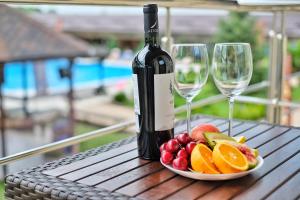 a bottle of wine and two glasses of fruit on a table at Rasputin Hotel in Mostovskoy