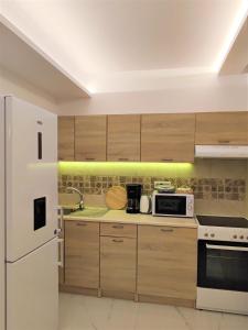 a kitchen with wooden cabinets and a white refrigerator at Villa Pavlina in Ixia