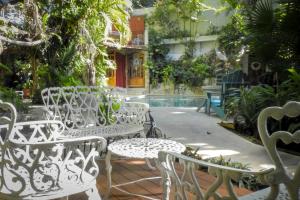 un groupe de chaises blanches assises à côté d'une piscine dans l'établissement Eco-hotel El Rey del Caribe, à Cancún