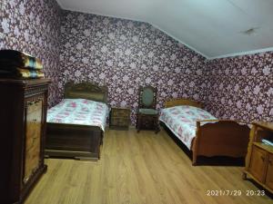 a bedroom with two beds and floral wallpaper at Green House Nakra in Naki