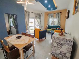 uma sala de estar com uma mesa e uma sala de jantar em MOOKSQUARE GJ SPOT em Douala