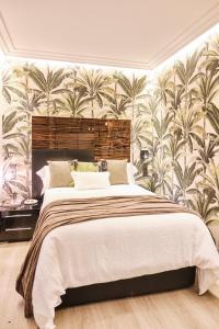 a bedroom with a large bed with a floral wallpaper at Apartamentos Pedreira Casa Historica Down Town in Pontevedra