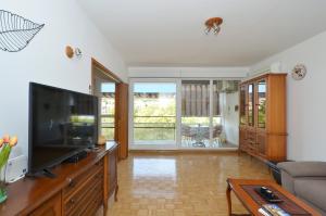 salon z telewizorem i kanapą w obiekcie Apartman Lazy Summer Days w Splicie