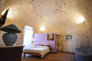 a bedroom with a bed and a brick wall at Domus Castrum in Bisceglie