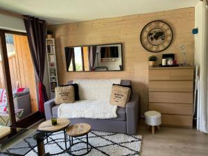 Studio Turquoise quartier Grattague vue MontBlanc في سان جيرفيه ليه بان: غرفة معيشة مع أريكة وساعة على الحائط